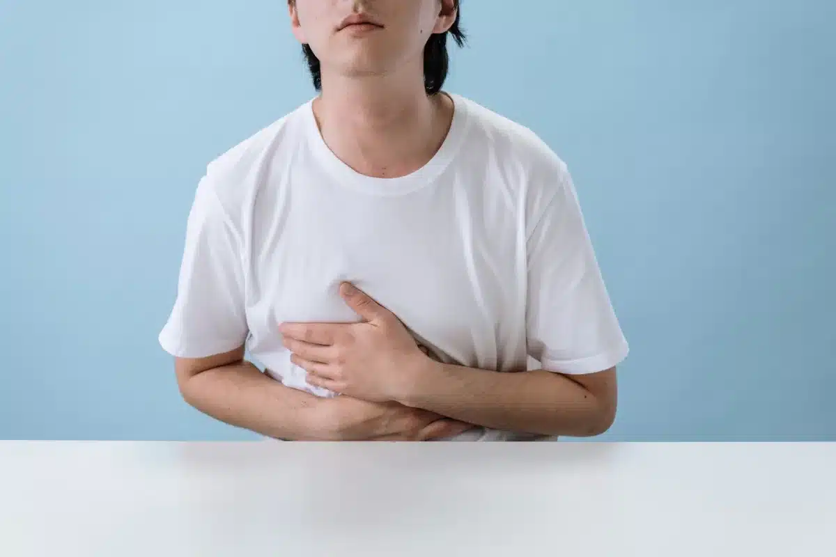Personne ressentant une gêne digestive, main sur l'abdomen