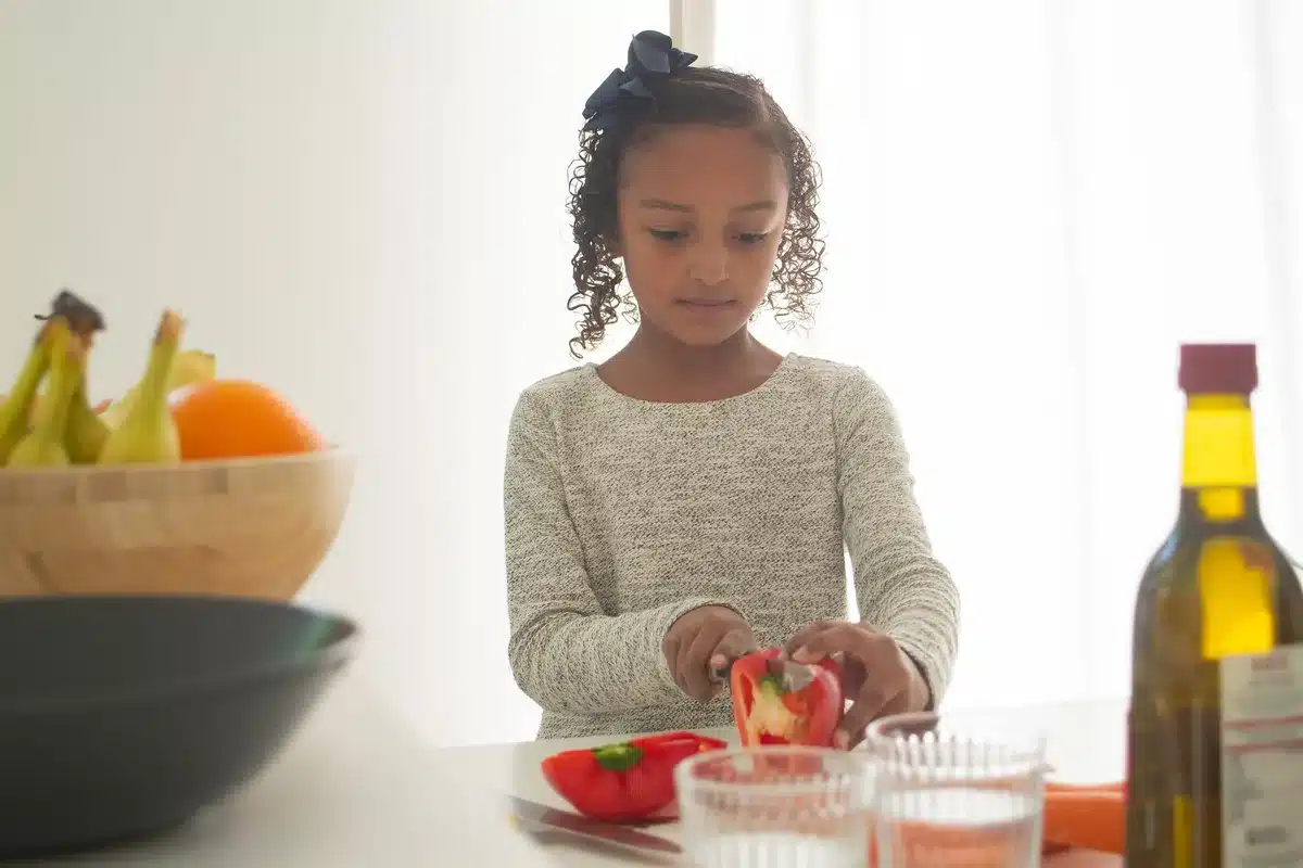 Enfant assis correctement à table, sans distraction, en train de manger attentivement