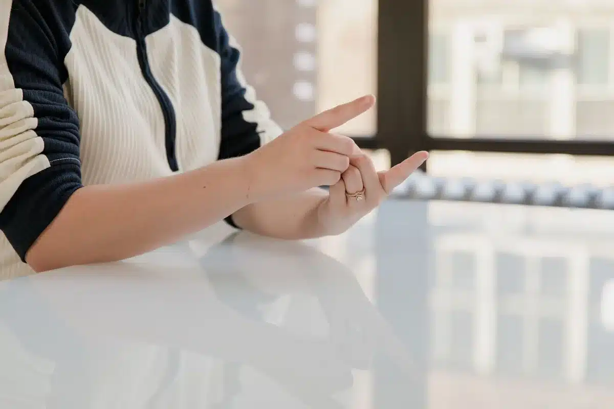 Personne se tenant l'oreille avec un geste de malaise