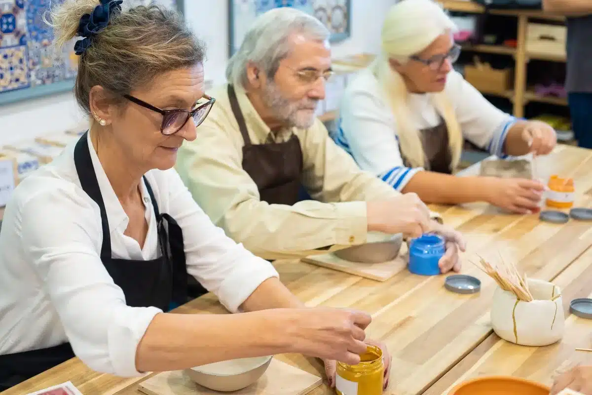 Personnes participant ensemble à un atelier de poterie autour d'une table