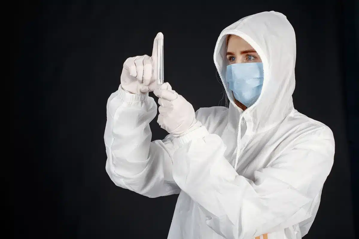 Professionnel de santé portant gants et masque, préparant un test médical en laboratoire