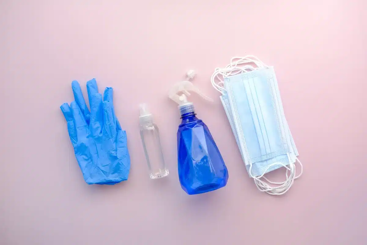 Équipement de protection : gants, masque et produit désinfectant pour un nettoyage sécurisé
