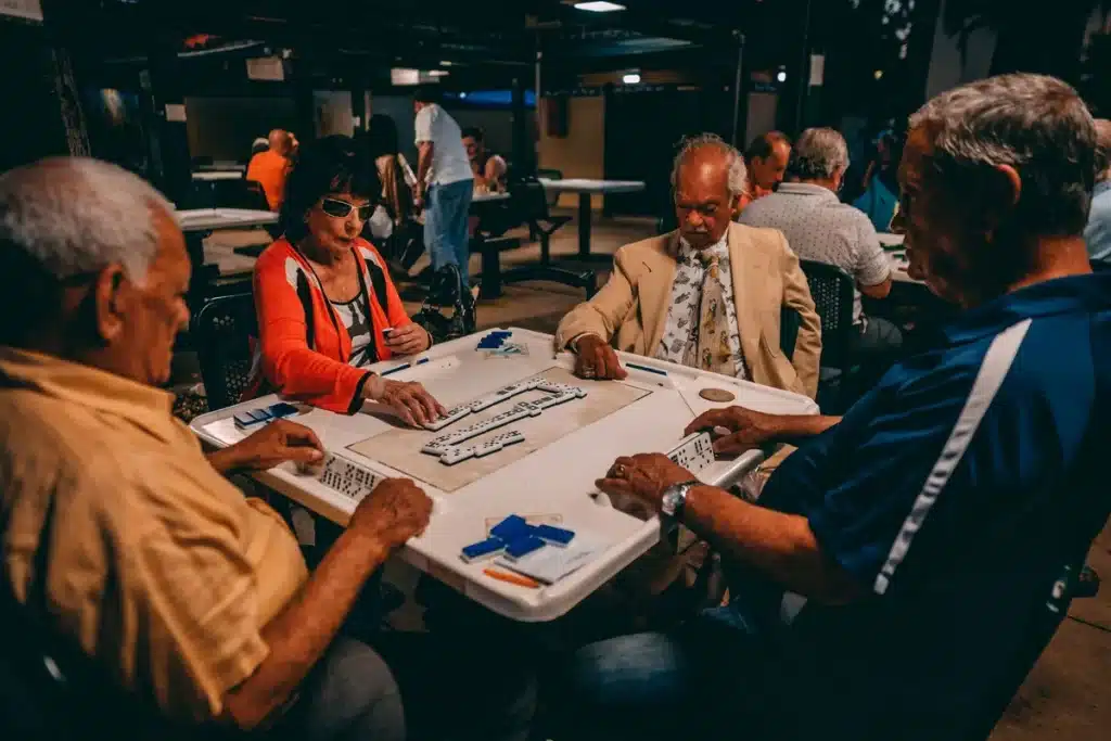 Joueur pensif arrangeant des tuiles de mahjong autour d'une table de jeu