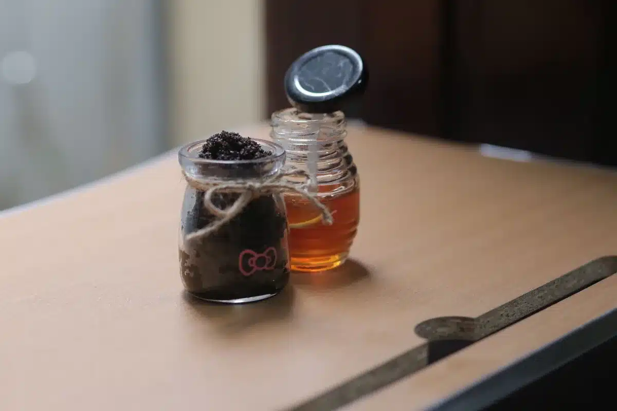 Pot de miel cristallisé avec des micro-cristaux dorés visibles en gros plan
