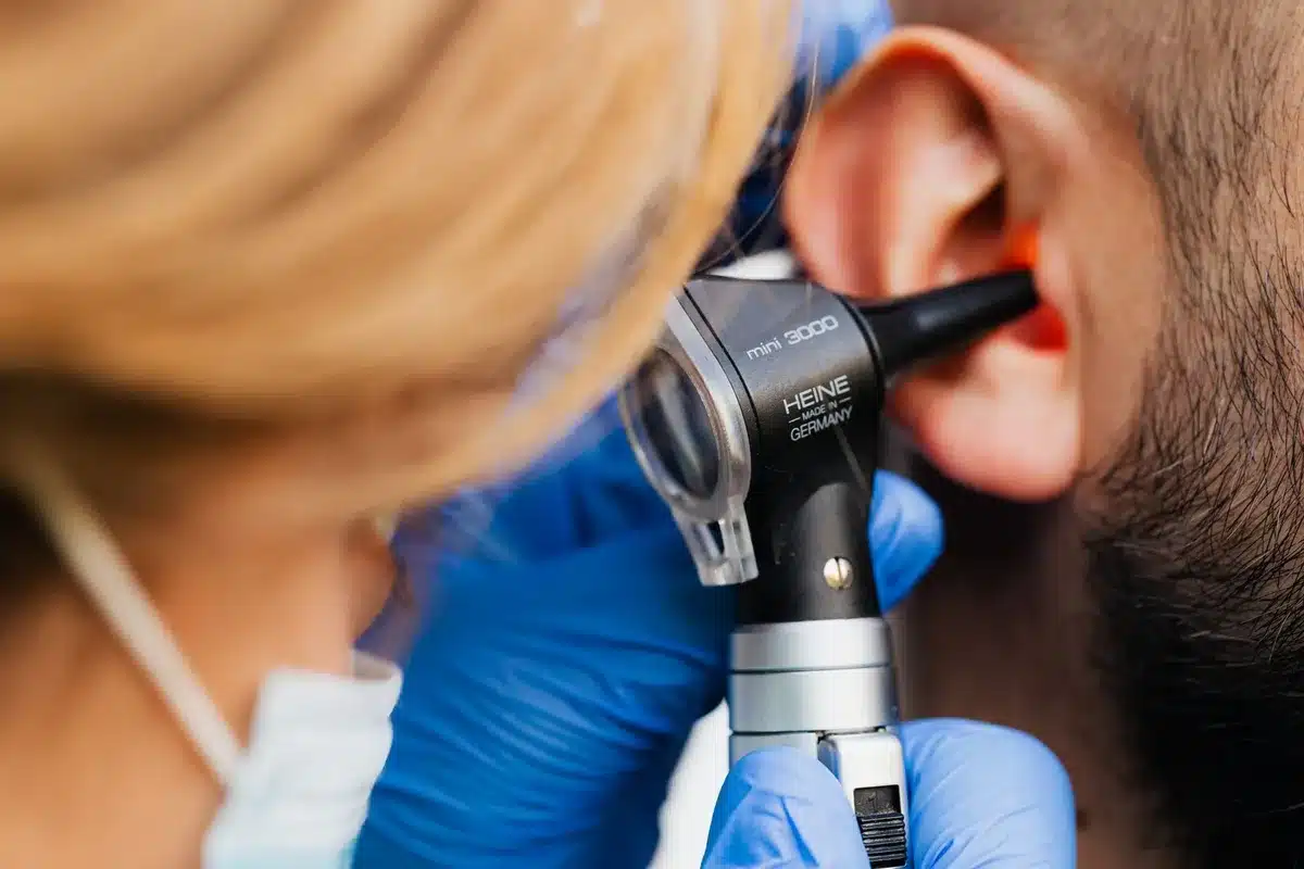 Un médecin ORL examinant l'oreille d'un patient avec un otoscope