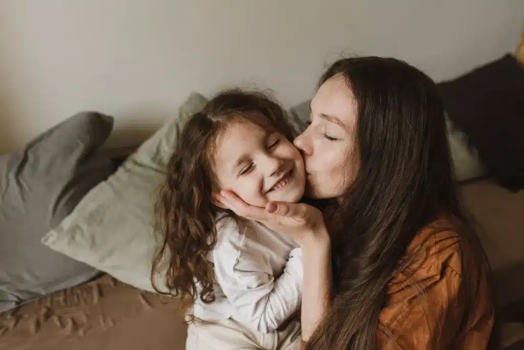 Un enfant se touchant l'oreille à la maison, avec une télévision en arrière-plan