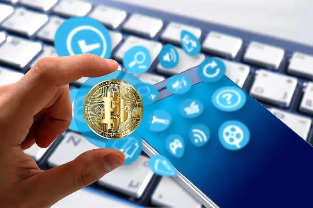 Mains tenant un téléphone affichant des graphiques de prix avec des symboles de cryptomonnaie