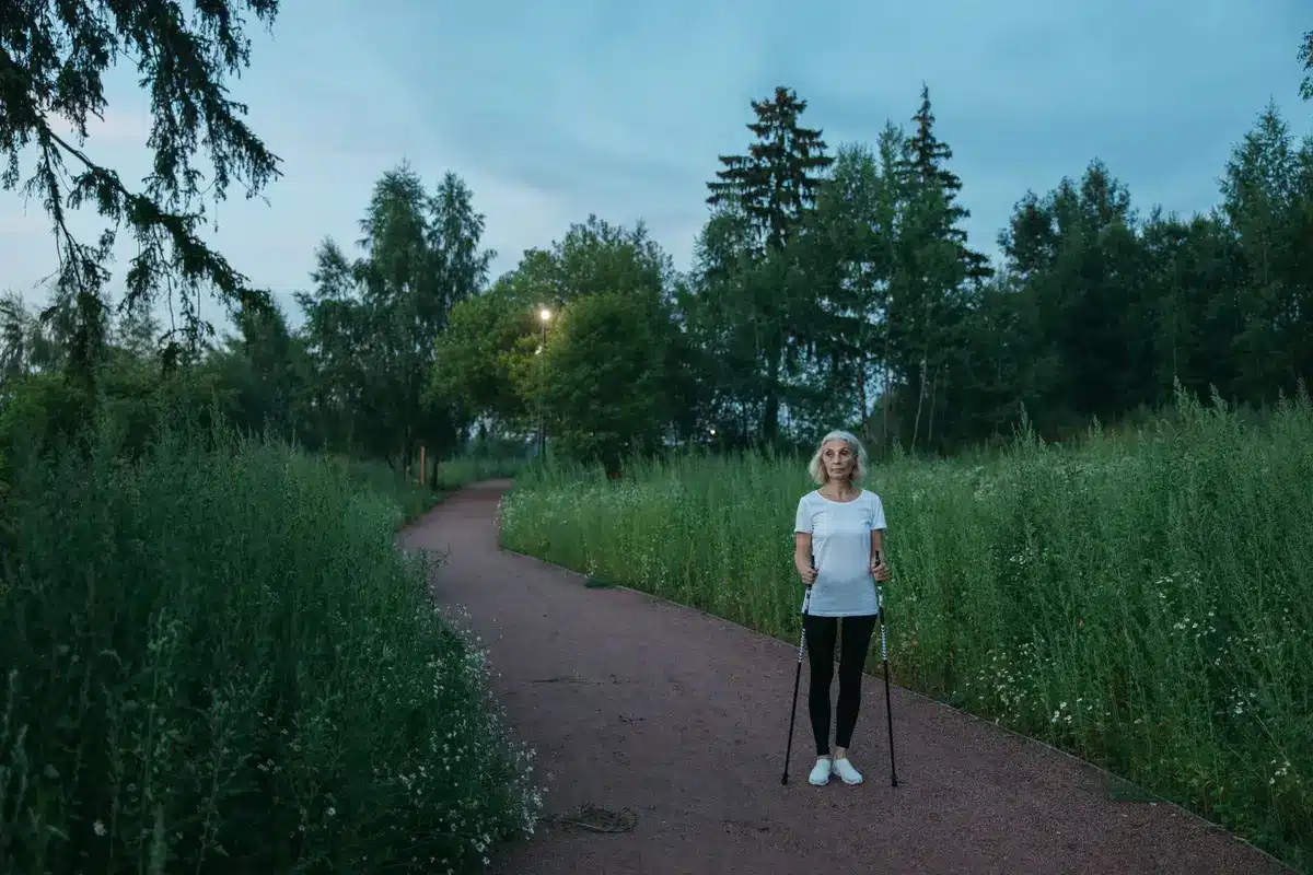 Personne âgée marchant en plein air, illustration de l'activité physique régulière bénéfique