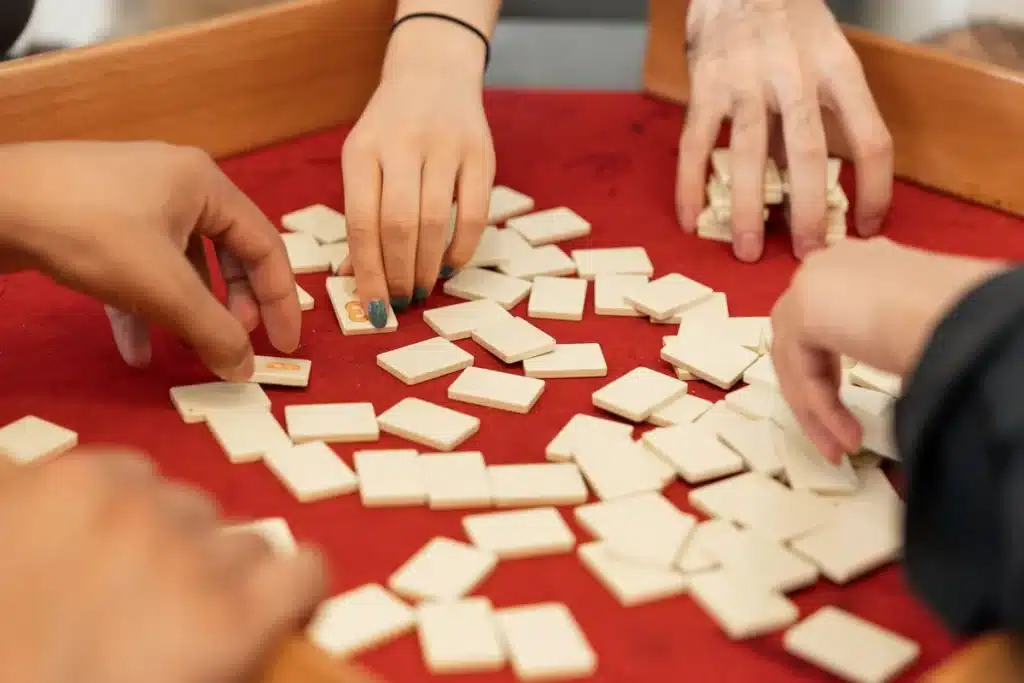 Tuiles de mahjong blanc et dragons colorés disposées sur une table de jeu