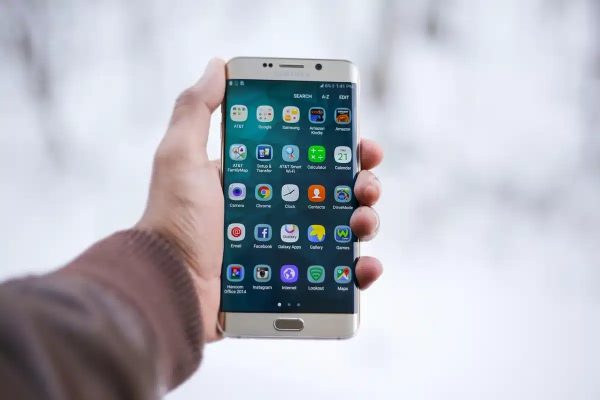 Smartphone affichant une application de casino floue sur un bureau en plein jour
