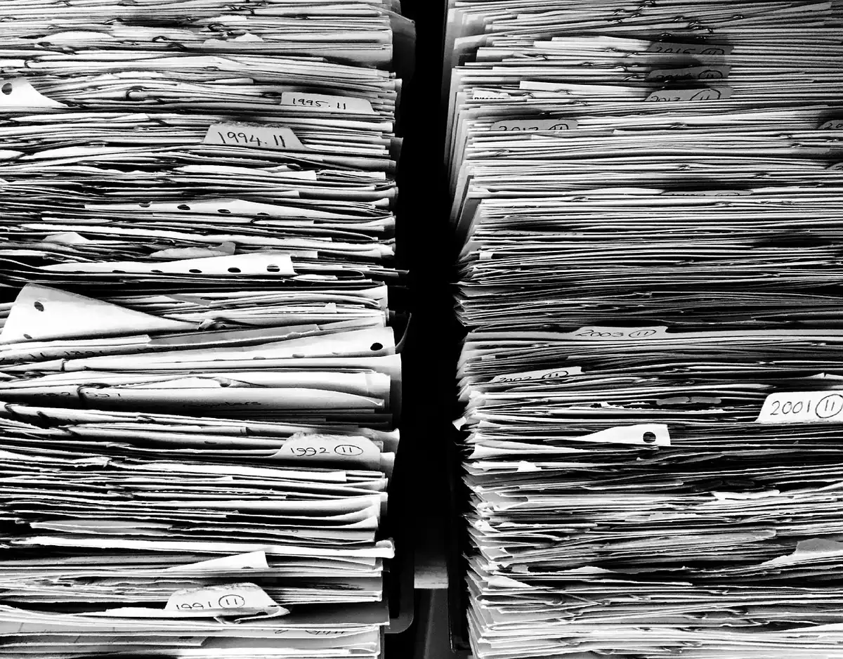 Accueil d'hôpital en plein jour, mains échangeant des documents près d'un comptoir
