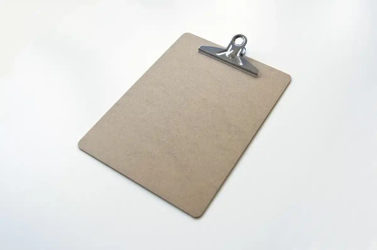 Checklist et documents d'identification posés sur un bureau en plein jour
