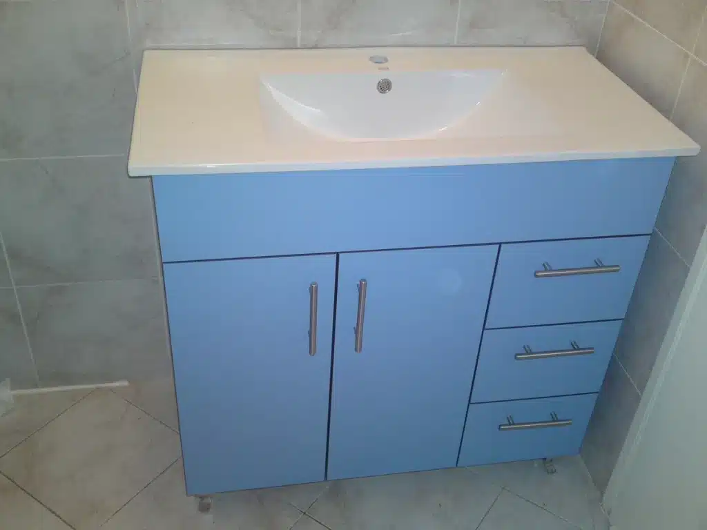 Gaine souple vide et flacon de lubrifiant sur un plan de toilette, vue rapprochée