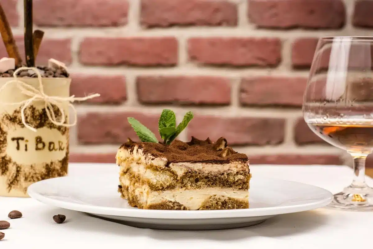 Trois petites cuillères contenant cannelle, cacao et extrait de vanille à côté d'une tasse
