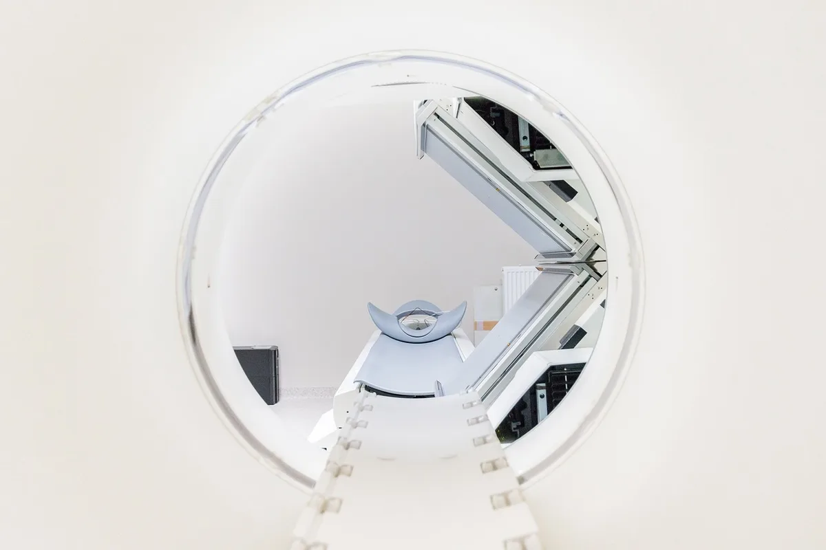 Radiographie du rachis sur un écran et mains d'un radiologue pointant l'image