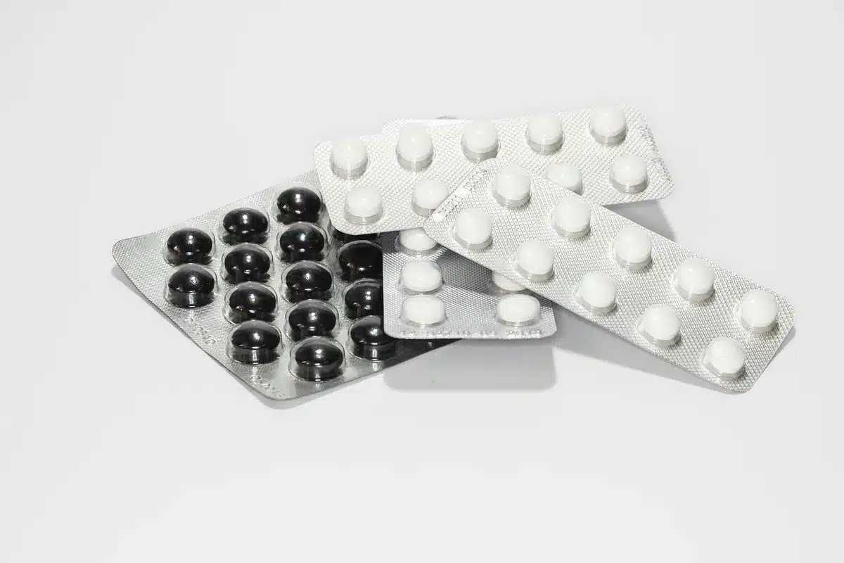 Boîte et comprimés de médicaments contre le rhume posés sur une table, étiquettes visibles