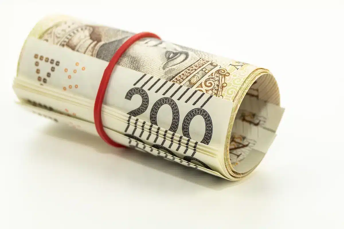 Tableur bancaire sur un écran et une main avec un carnet