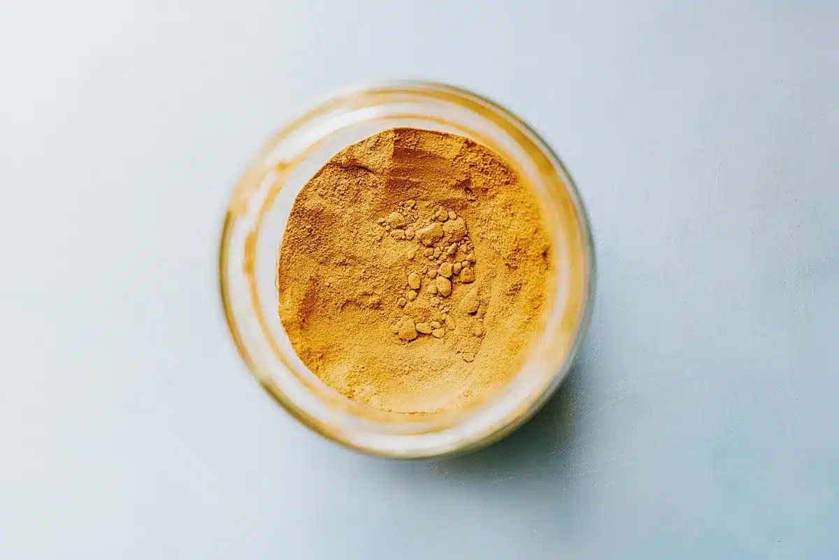 Différents pots de poudre protéinée (whey et végétales) sur un plan de travail