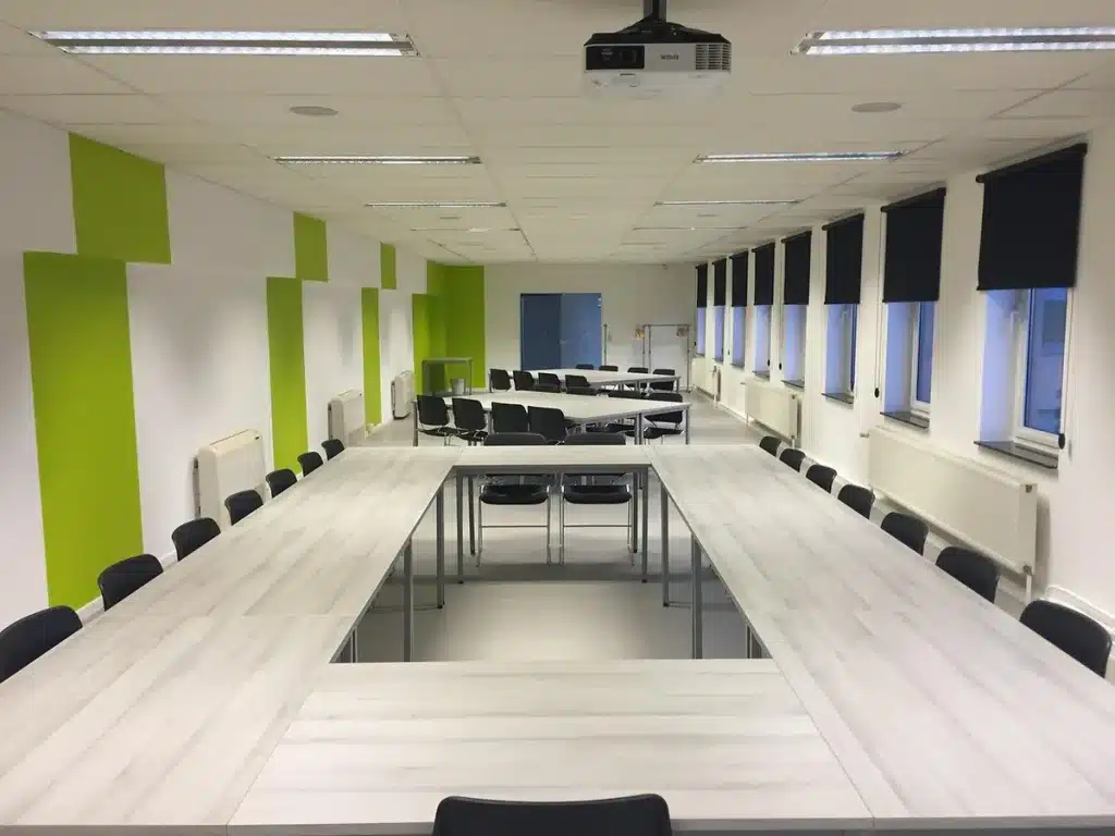 Salle de consultation audiologie en plein jour, documents audiométriques et étuis d'appareils auditifs sur une table