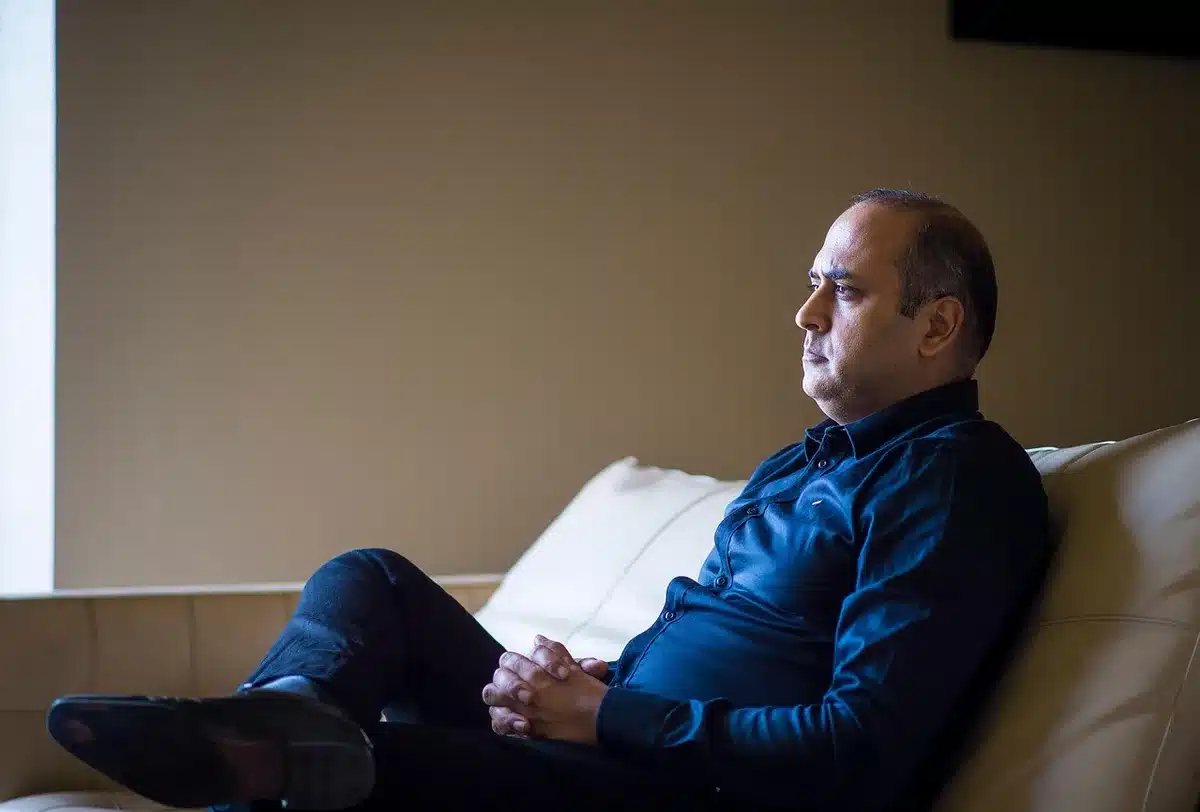 Personne assise au fauteuil, l'air fatigué et enveloppée d'un plaid